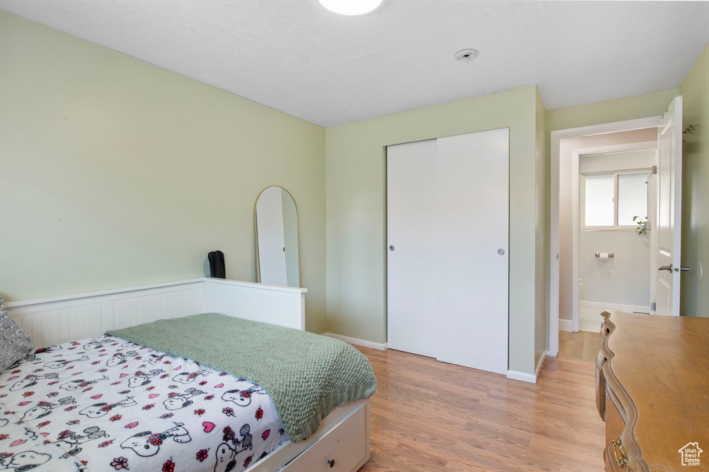 Bedroom featuring light wood-style flooring and a closet