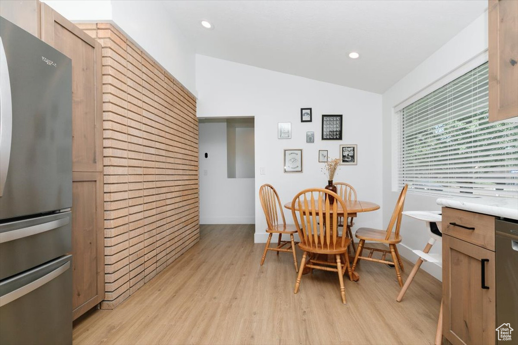 Dining room featuring lofted ceiling, light wood-style flooring, and recessed lighting