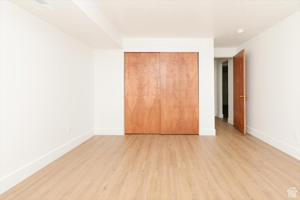 Unfurnished bedroom featuring light wood-style floors and a closet