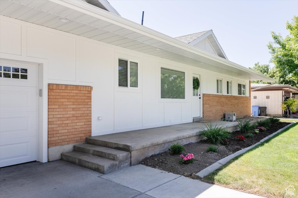 View of exterior entry with brick siding and board and batten siding