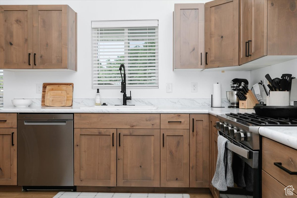 Kitchen with appliances with stainless steel finishes, light countertops, and brown cabinets