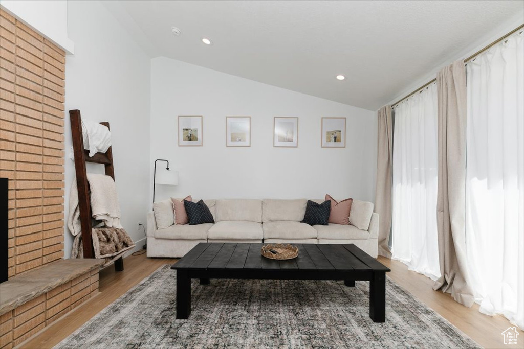 Living room with vaulted ceiling, wood finished floors, and recessed lighting