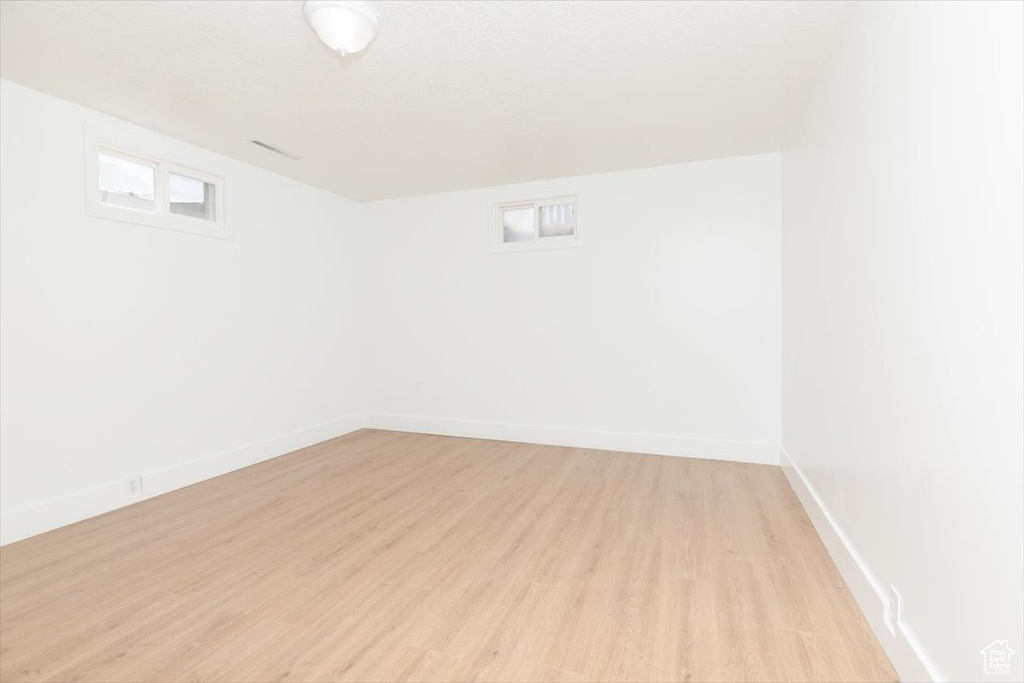 Empty room with light wood-type flooring and baseboards