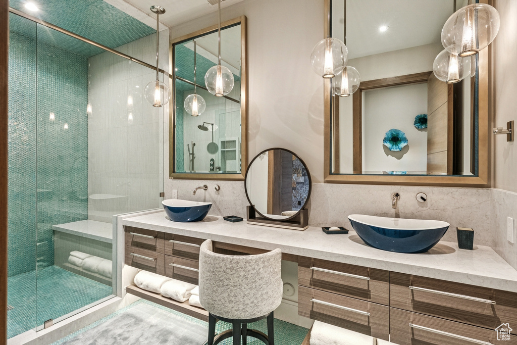 Full bathroom with a stall shower, double vanity, and backsplash