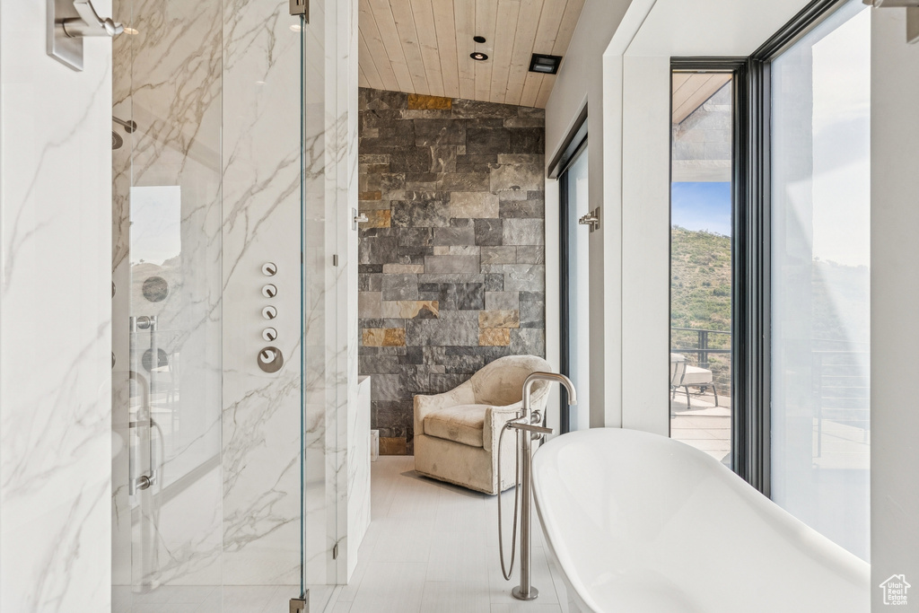 Full bathroom with a marble finish shower, a freestanding bath, and wood ceiling