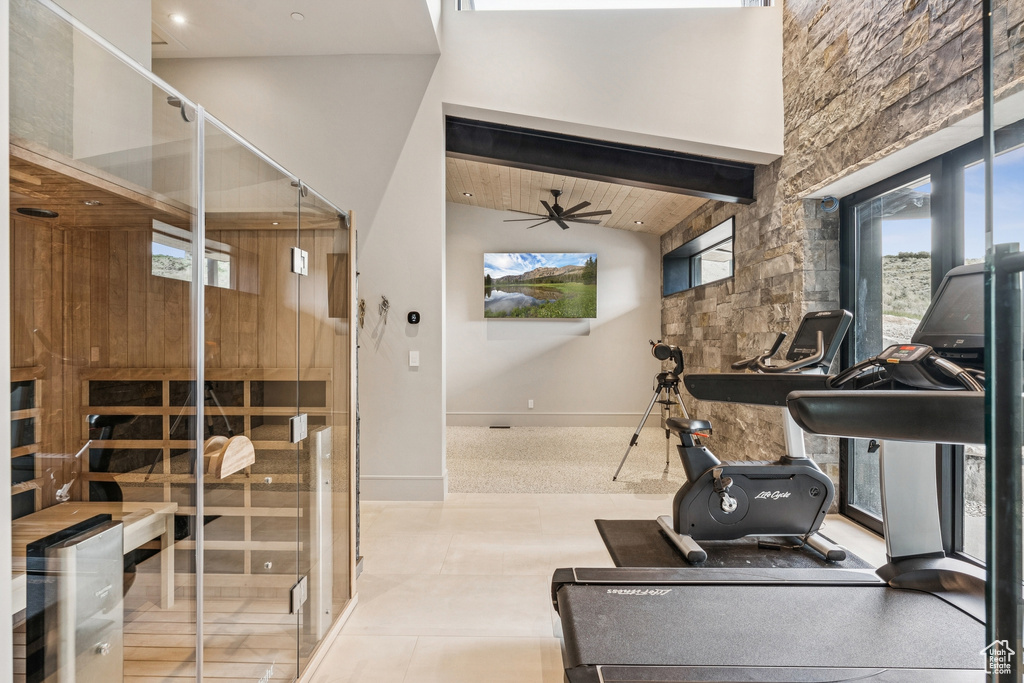 Workout room with ceiling fan, high vaulted ceiling, and a relaxing sauna