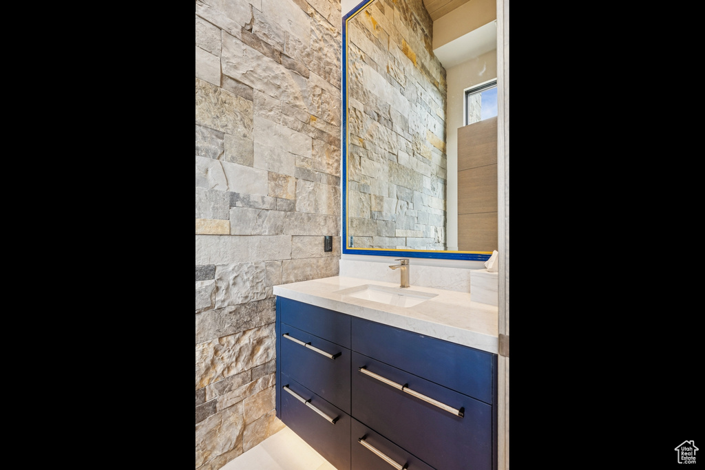 Bathroom featuring vanity and tile walls