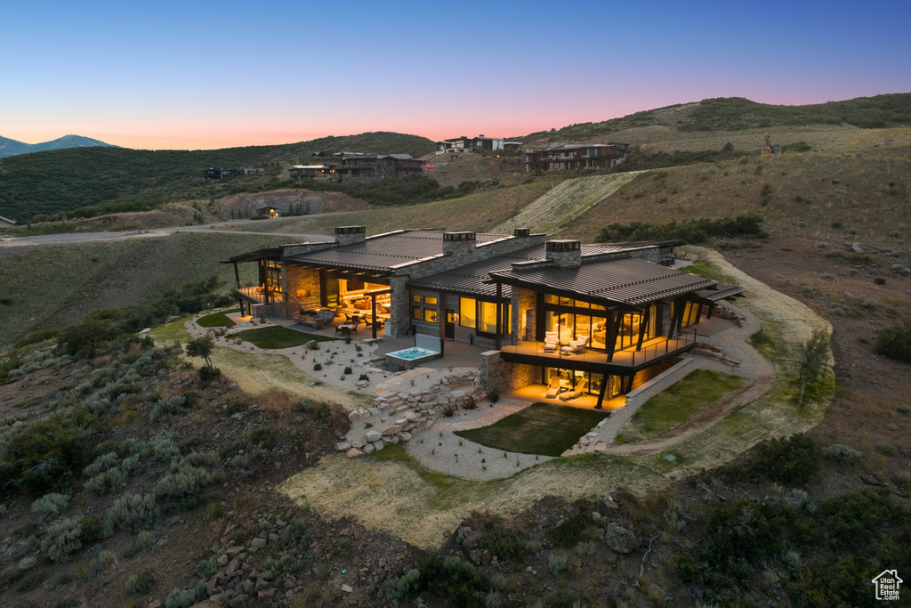 Back of house featuring a patio, a chimney, a mountain view, and a metal roof