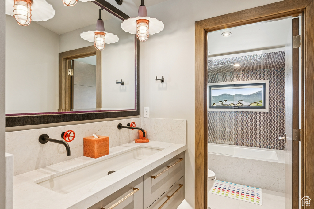 Bathroom featuring tasteful backsplash, vanity, and a tub to relax in