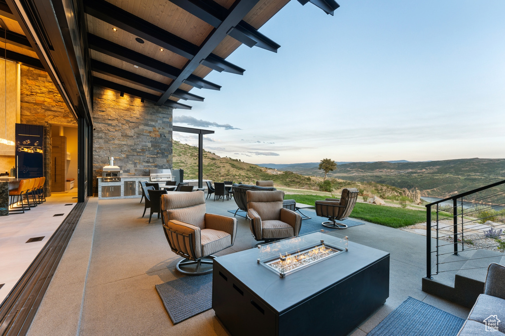 View of patio / terrace with a mountain view, an outdoor living space with a fire pit, and area for grilling