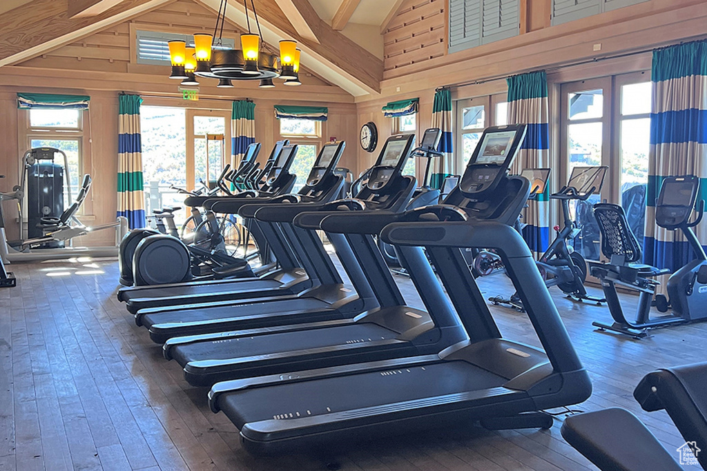 Workout area with hardwood / wood-style floors, wooden walls, and a chandelier