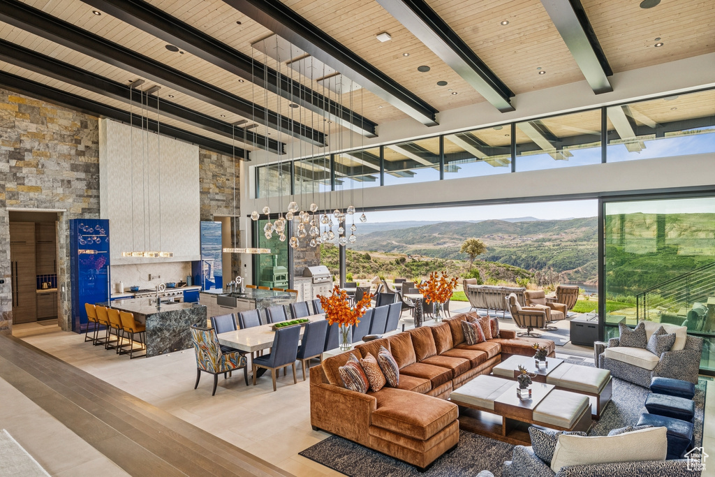 Living area featuring wood finished floors, a mountain view, a wood ceiling with exposed beams, and a high ceiling