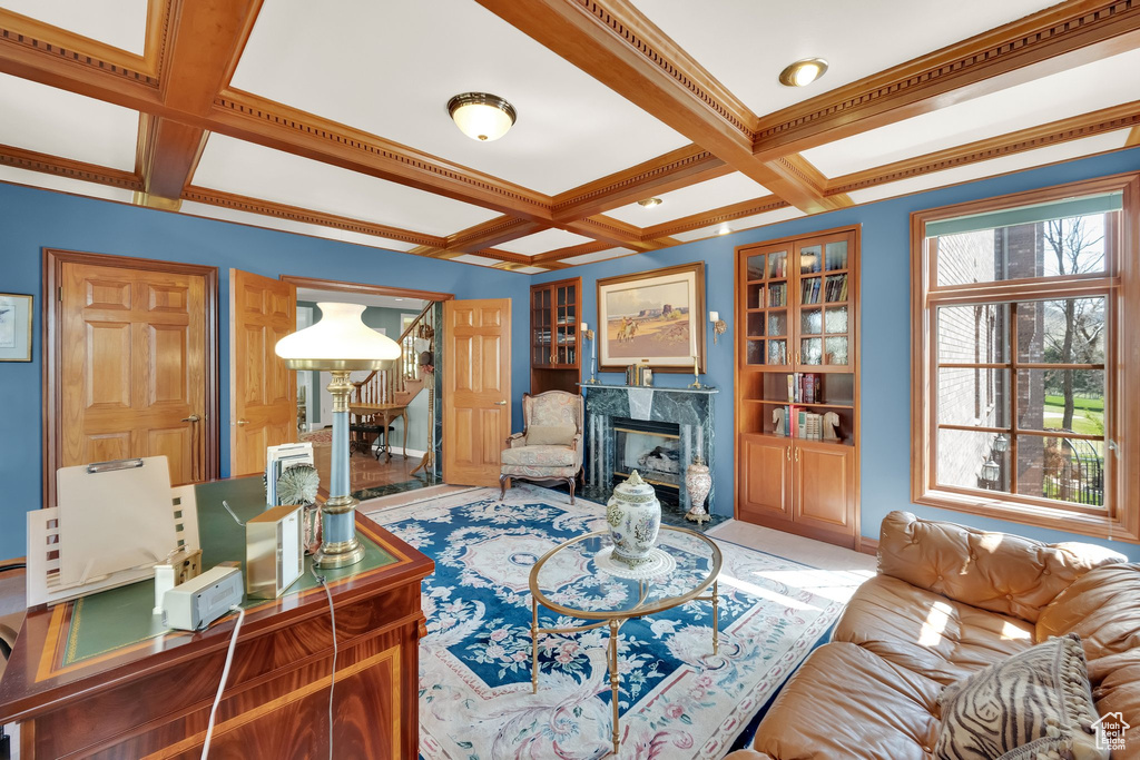 Living room featuring coffered ceiling, stairs, beam ceiling, and a premium fireplace