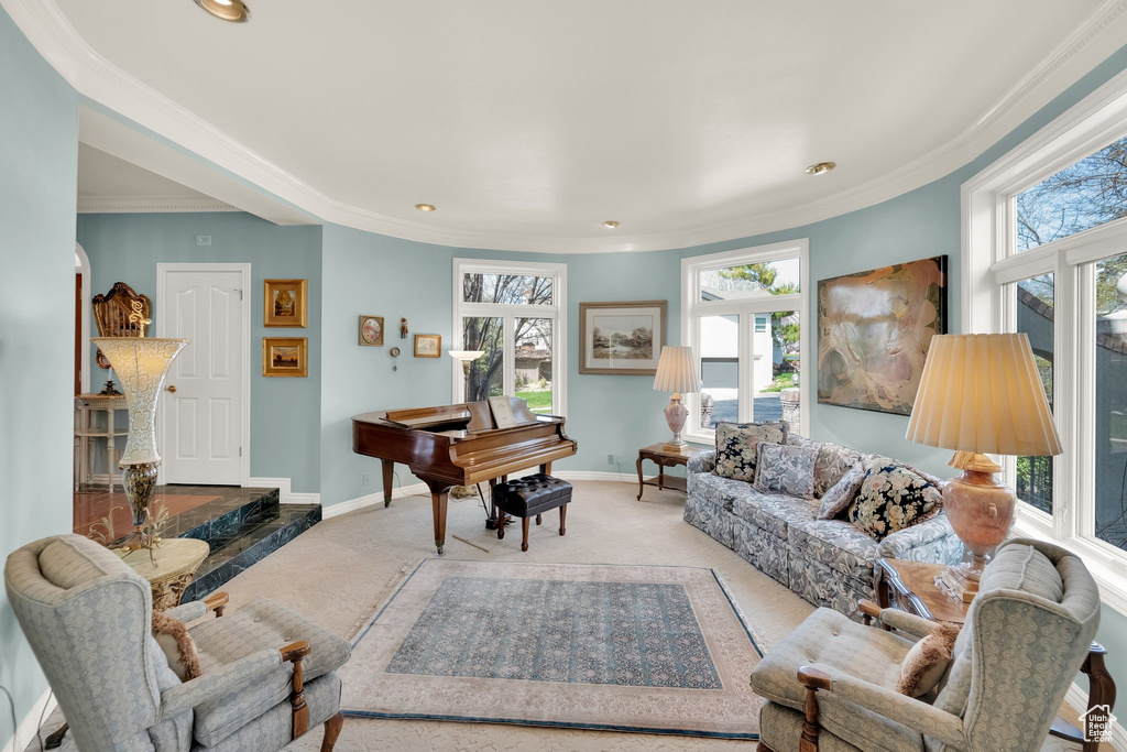 Carpeted living area with plenty of natural light, recessed lighting, and ornamental molding