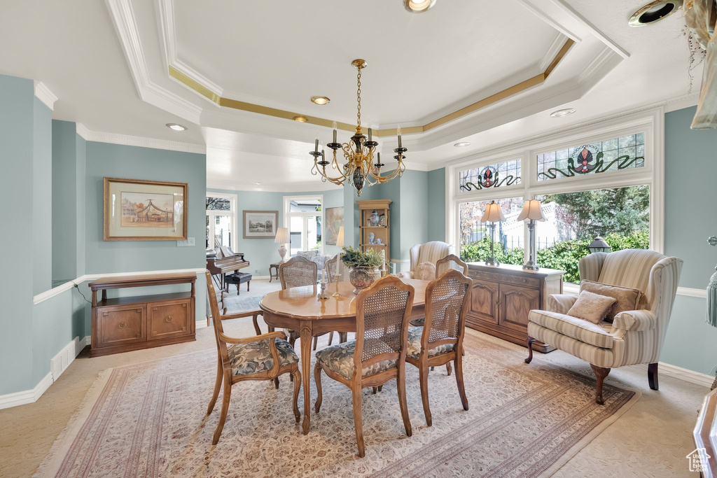 Dining room with a chandelier, a tray ceiling, recessed lighting, and crown molding