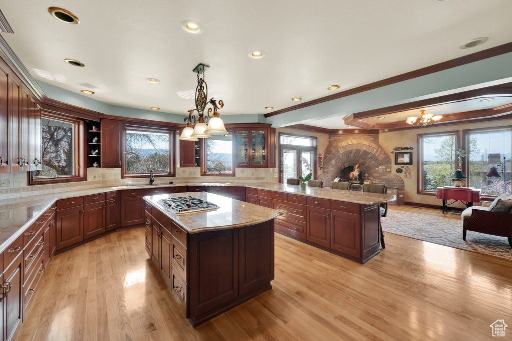 Kitchen featuring a chandelier, open floor plan, light wood-style floors, stainless steel gas cooktop, and recessed lighting