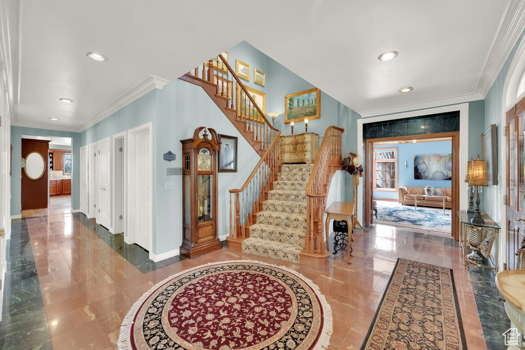 Entrance foyer featuring marble tiled flooring, stairs, recessed lighting, and ornamental molding