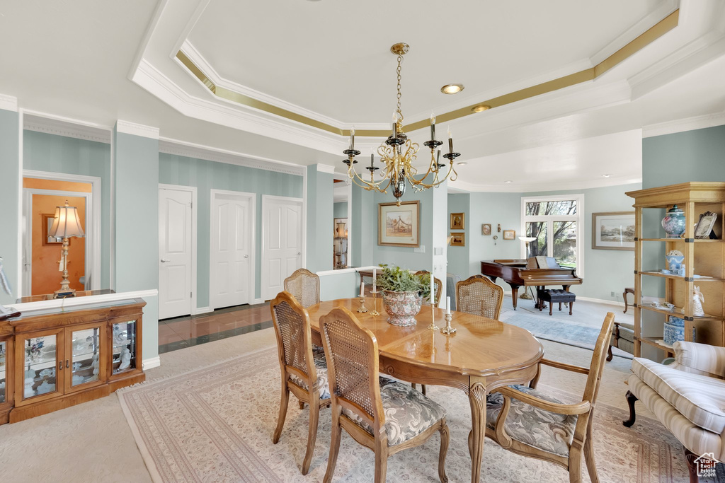 Dining room featuring a raised ceiling, crown molding, a chandelier, and recessed lighting
