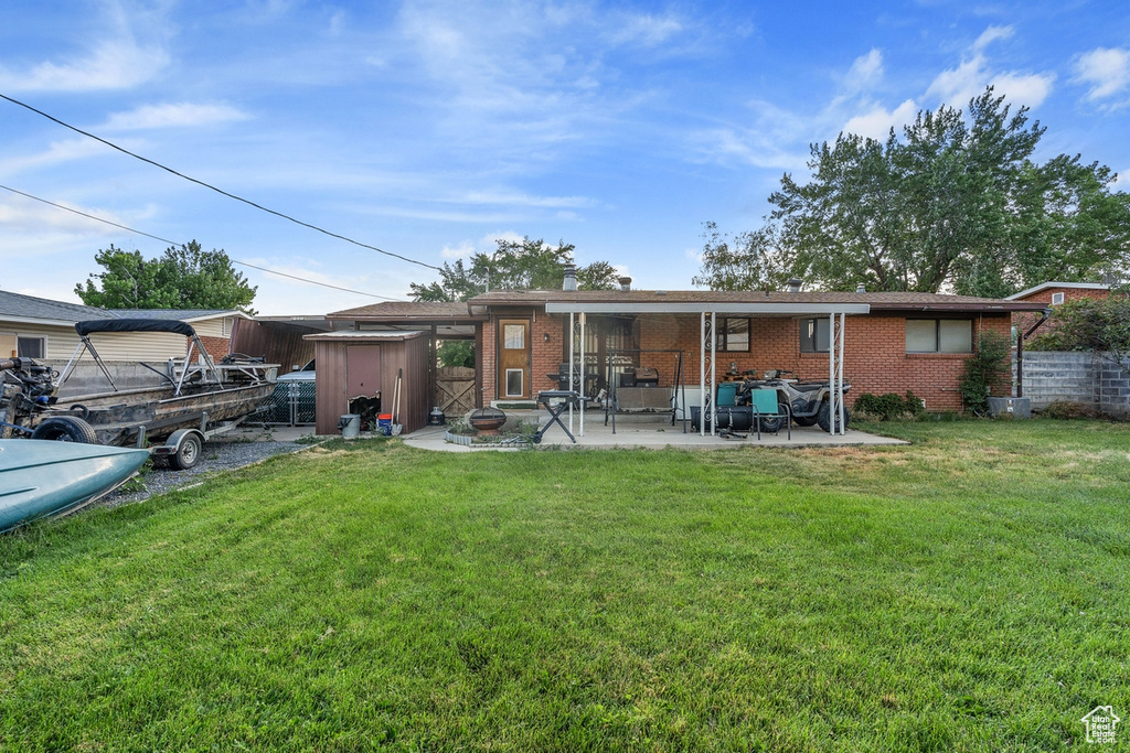 Back of house with brick siding, a patio area, a yard, and an outdoor living space
