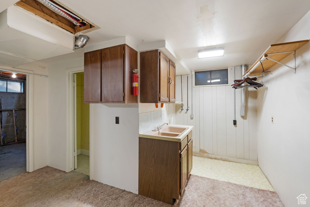Laundry area with a sink and light colored carpet