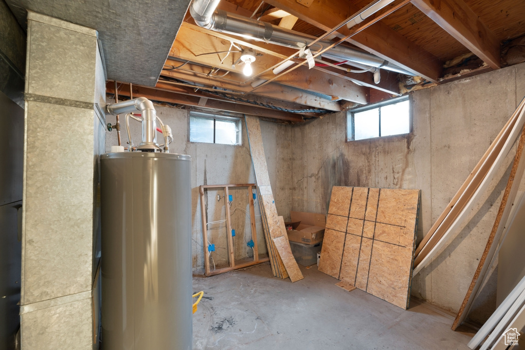 Basement with water heater and healthy amount of natural light