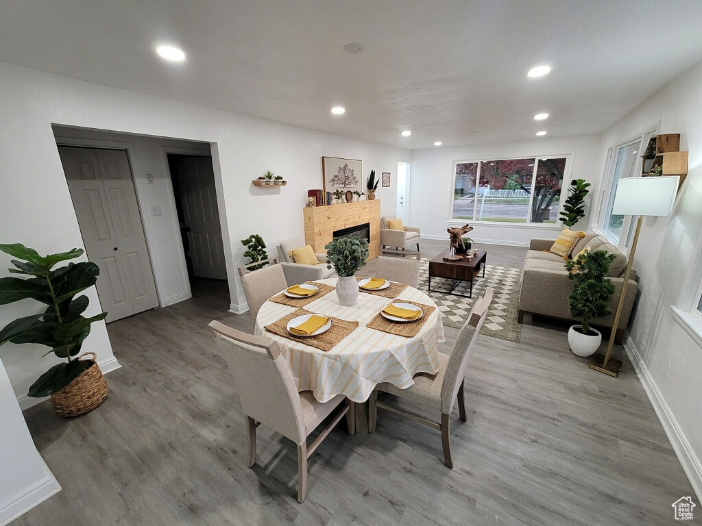 Dining space featuring light wood-style flooring, a fireplace, and recessed lighting