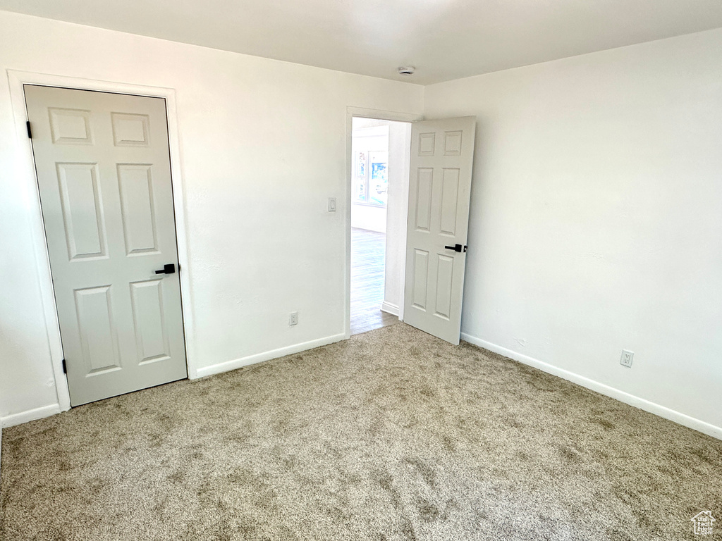 Unfurnished bedroom with carpet and baseboards