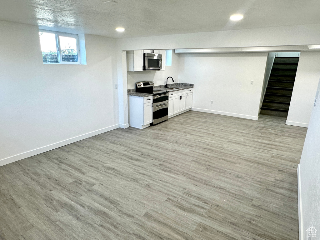 Bar featuring stainless steel appliances, light wood-style floors, recessed lighting, and stairs