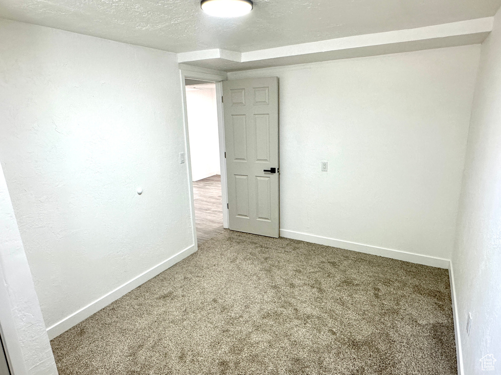 Carpeted spare room with baseboards