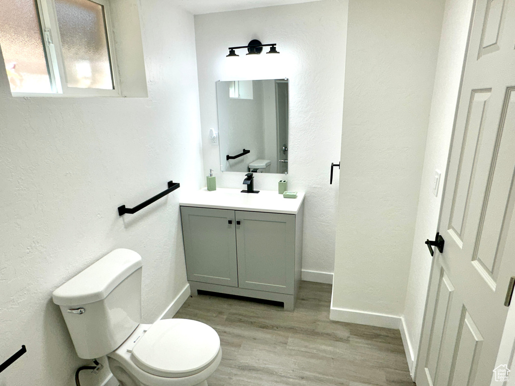 Bathroom featuring vanity, wood finished floors, and a textured wall