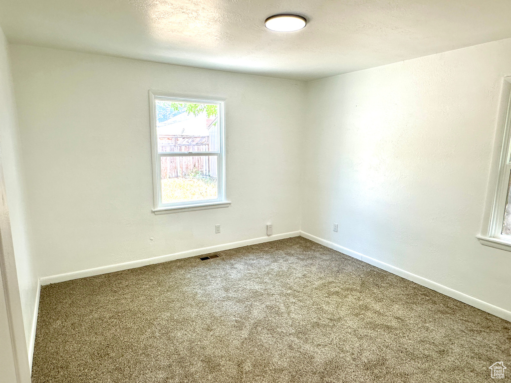 Spare room with carpet and baseboards
