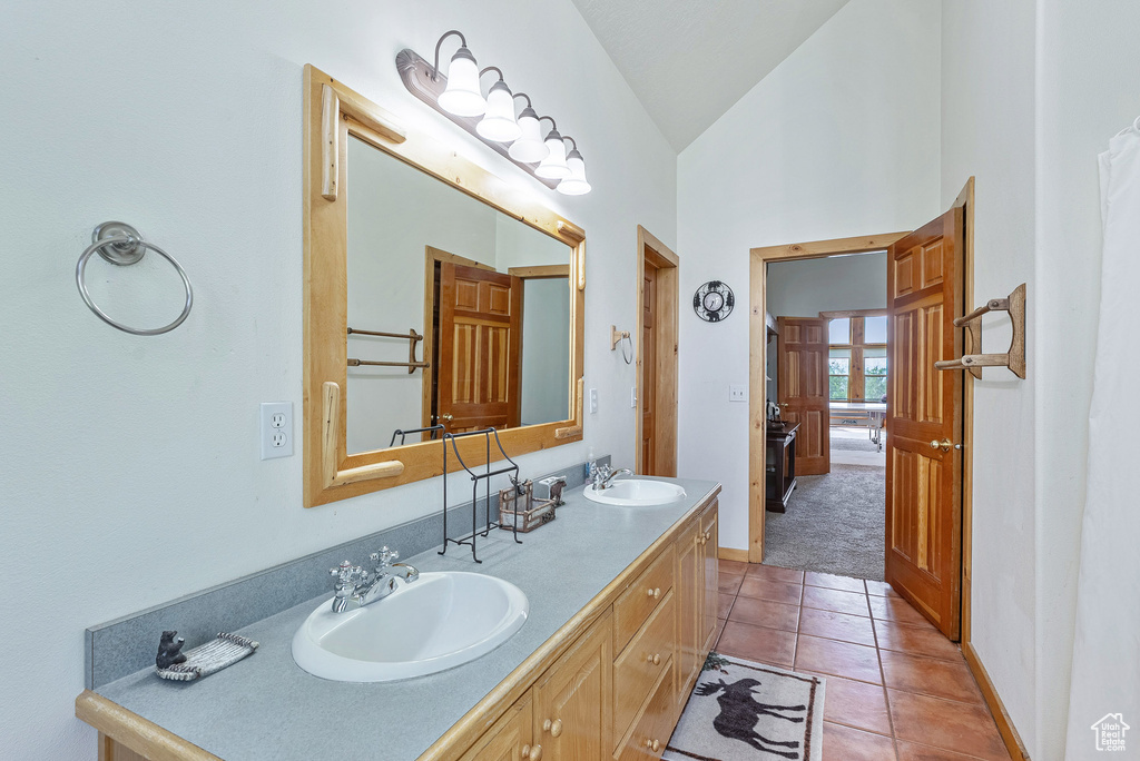 Full bathroom with tile patterned floors, double vanity, and high vaulted ceiling