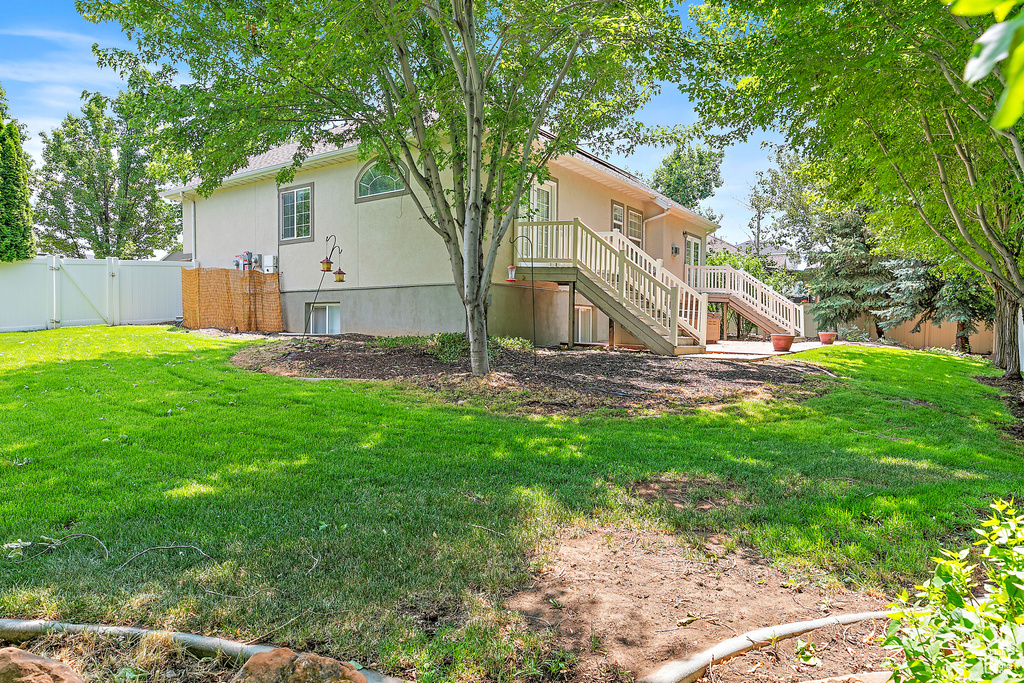 Back of property with a gate, stairway, and stucco siding