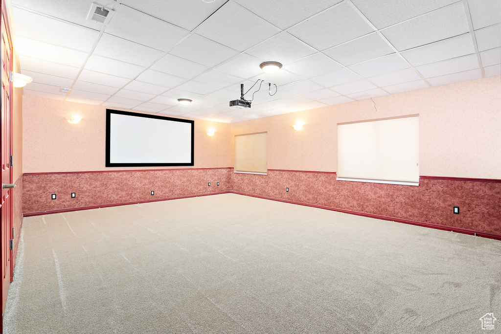 Cinema room with carpet floors, a drop ceiling, a wainscoted wall, and wallpapered walls