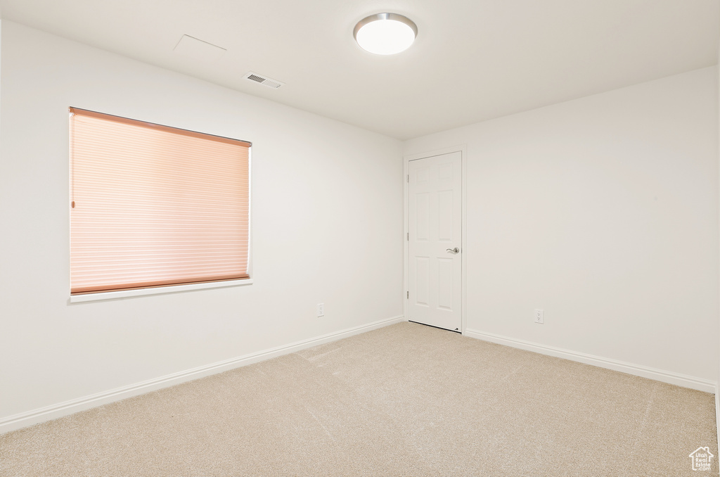 Spare room with light carpet and baseboards
