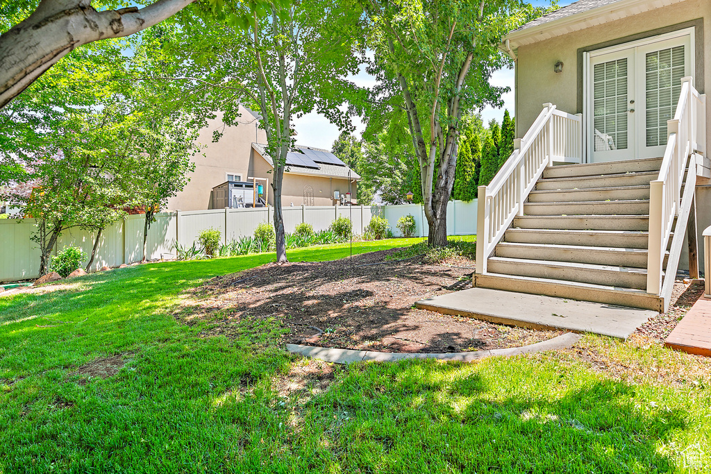 Fenced backyard featuring french doors