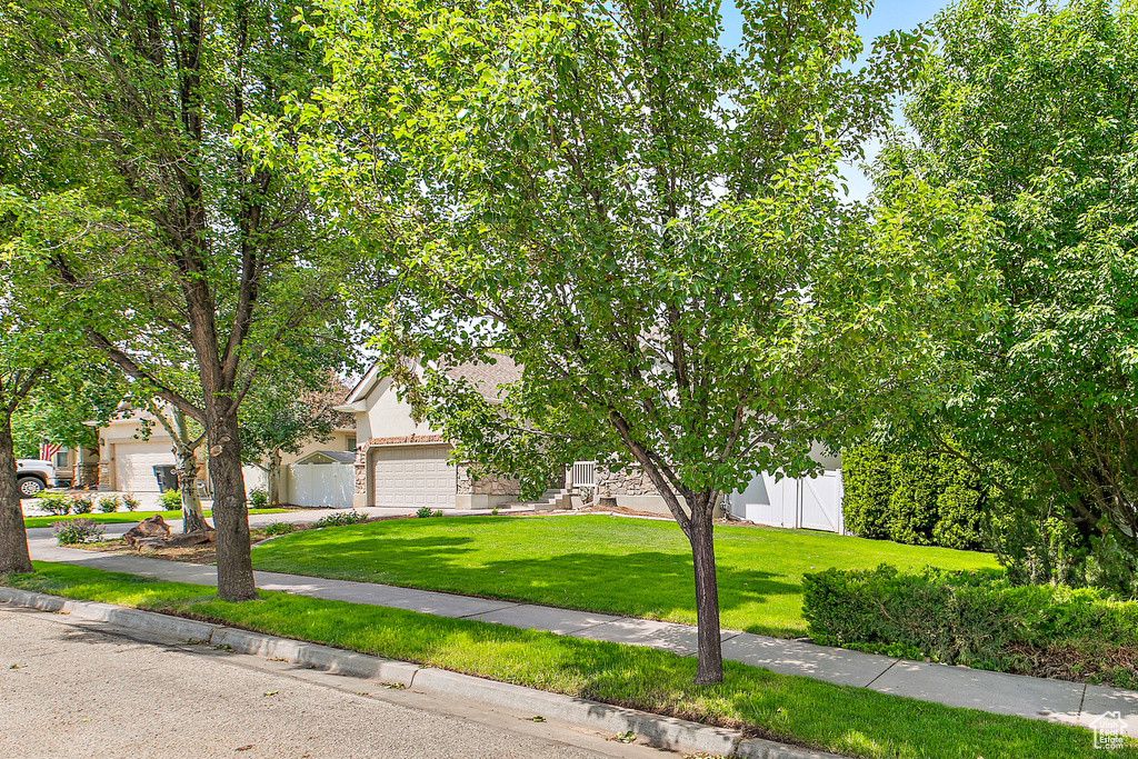Obstructed view of property featuring stucco siding, concrete driveway, and a garage