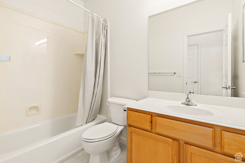 Full bathroom featuring vanity, shower / tub combo with curtain, and tile patterned floors
