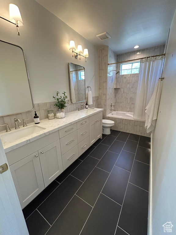 Bathroom with tiled shower / bath, tile patterned floors, and double vanity