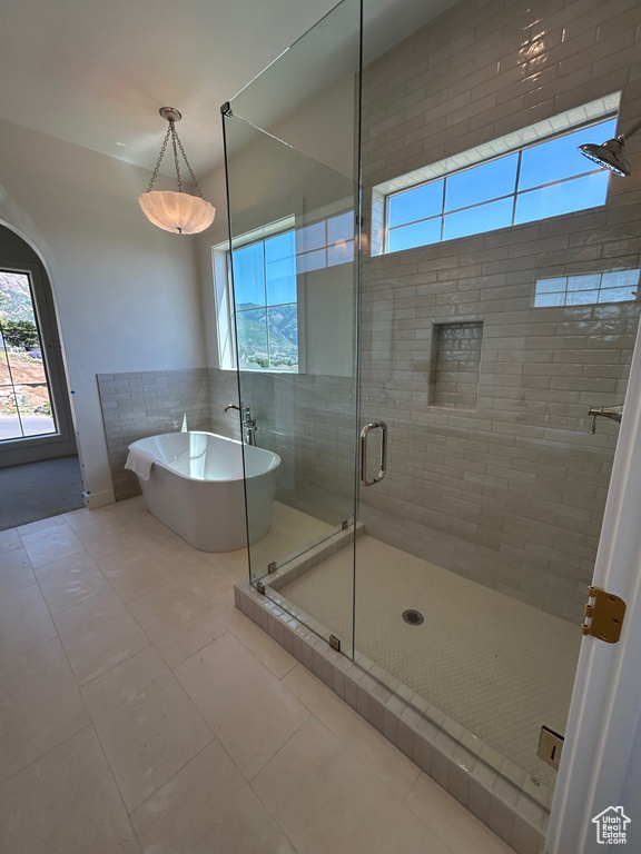 Bathroom featuring a shower stall, tile patterned flooring, and a freestanding bath