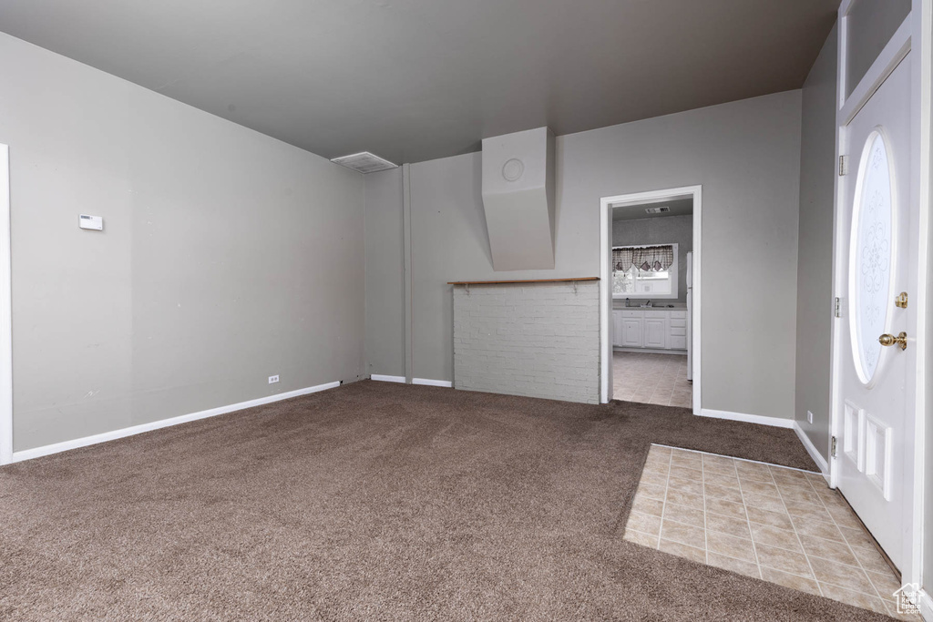 Foyer entrance with carpet flooring and baseboards