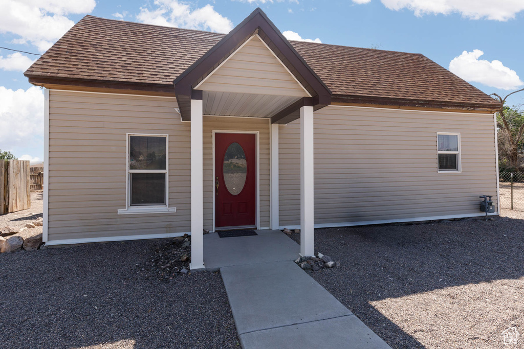 View of exterior entry with a shingled roof