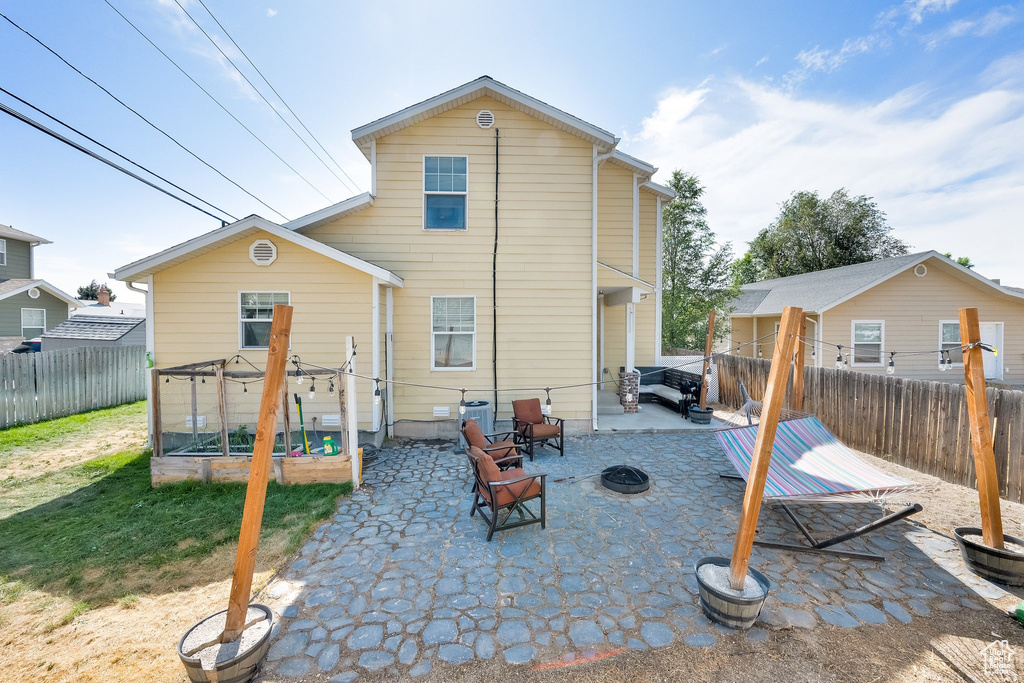 Back of house featuring a fenced backyard, a patio area, and a fire pit