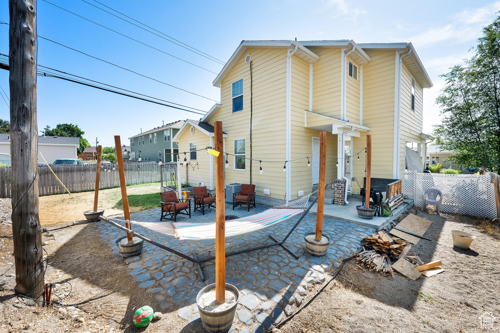Back of house with a fenced backyard, a patio area, and outdoor lounge area