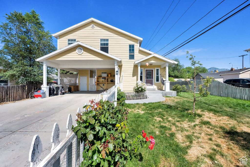 Traditional-style home with driveway, a carport, and covered porch