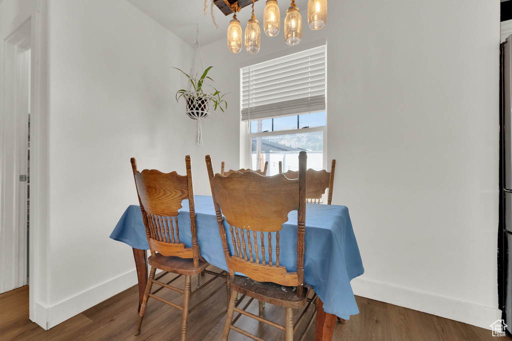 Dining area with wood finished floors and a chandelier