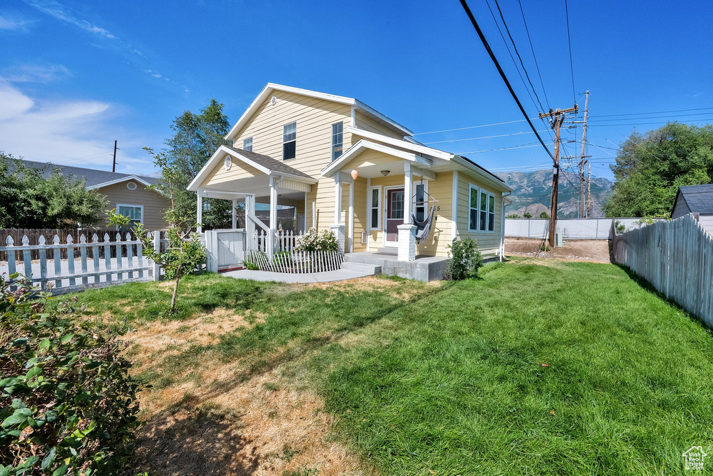 View of front of house featuring a porch and a fenced backyard