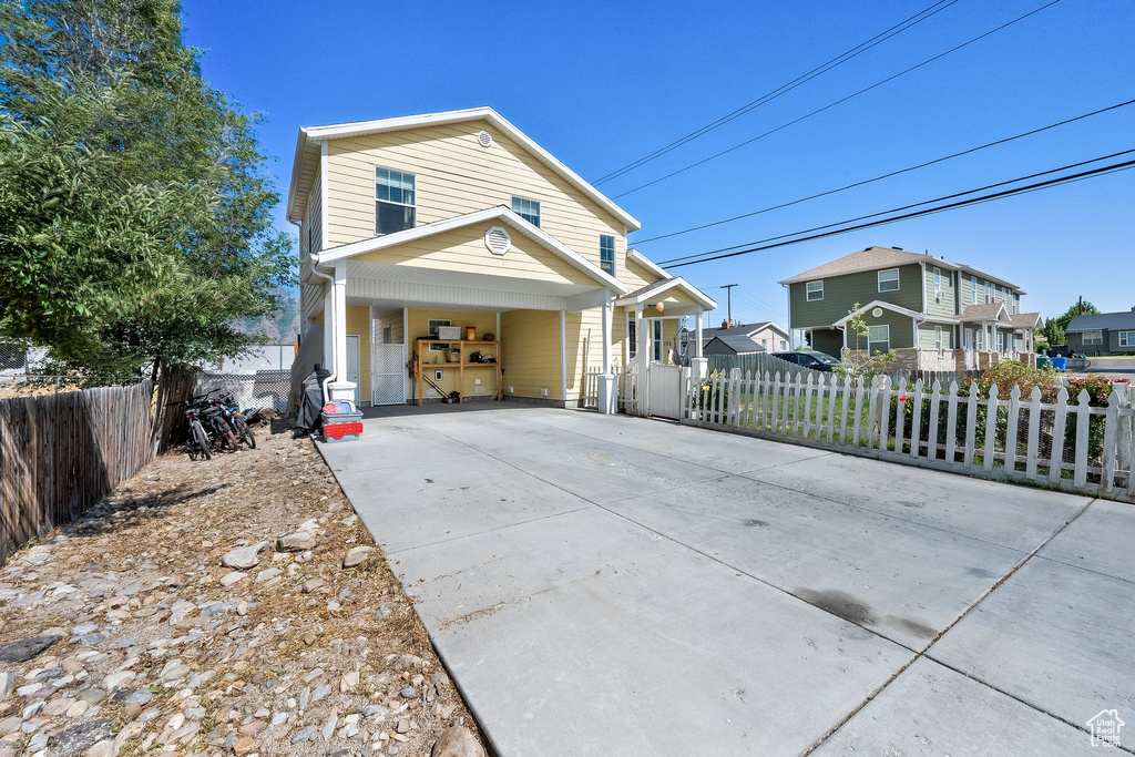 View of front of property with driveway, a porch, a residential view, and a carport