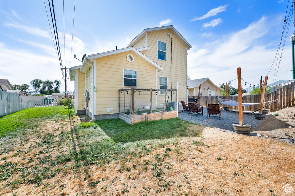 Rear view of house featuring a fenced backyard and a patio
