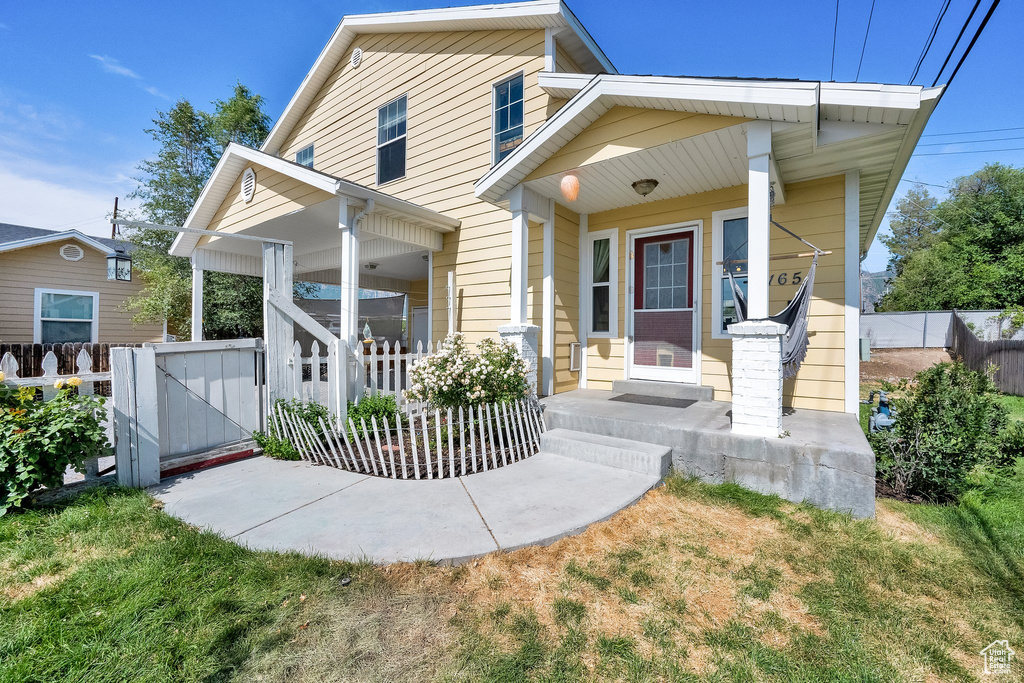 View of front of home with covered porch and a gate